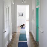 Un couloir avec un chien sur un tapis bleu.