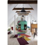Une chambre d'enfant avec un tapis coloré au sol.