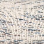 Un gros plan d'un tapis tissé bleu et blanc.