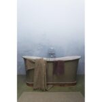 Une baignoire avec une serviette devant.