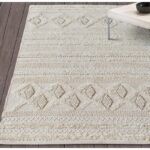 Un tapis beige au design géométrique.