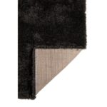Un tapis shaggy noir sur fond blanc.