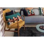 Un salon avec une chaise jaune et des oreillers.