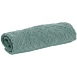 Une couverture tricotée verte sur fond blanc.