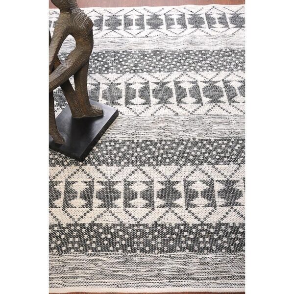 Un tapis noir et blanc avec une statue.