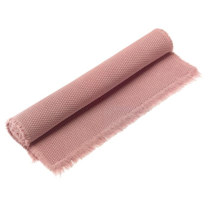 Un tapis rose à franges.