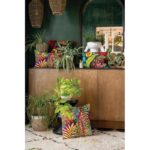 Un groupe d'oreillers colorés sur une table à côté d'une plante en pot.