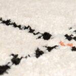 Un gros plan d'un tapis blanc à pois noirs.