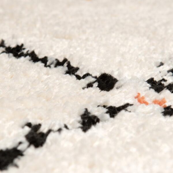 Un gros plan d'un tapis blanc à pois noirs.