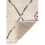 Un tapis blanc avec des franges colorées.