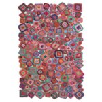 Un tapis au crochet coloré avec de nombreux carrés.