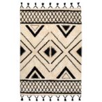 Un tapis noir et blanc avec des pompons.