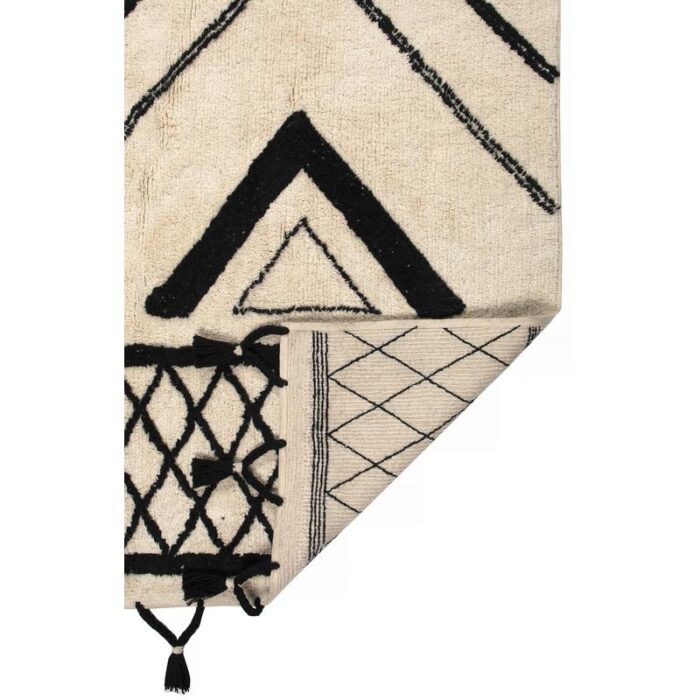 Un tapis noir et blanc avec des pompons.