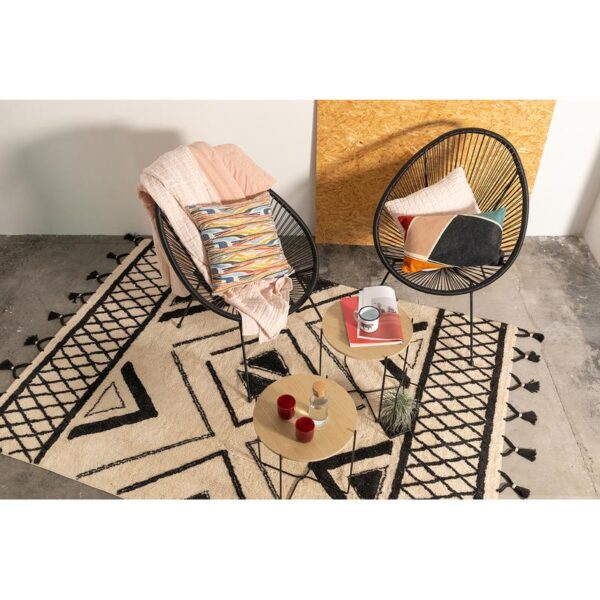 Deux chaises et un tapis devant un mur.