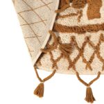 Un tapis beige avec des pompons.