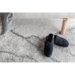 Une paire de chaussures noires sur un tapis.