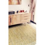 Un tapis jaune dans une pièce avec une commode blanche.