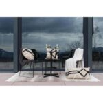 Une table et des chaises en noir et blanc devant une fenêtre.