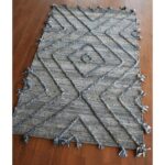 Un tapis gris à franges.