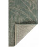 Un tapis d'extérieur au motif vert et beige.