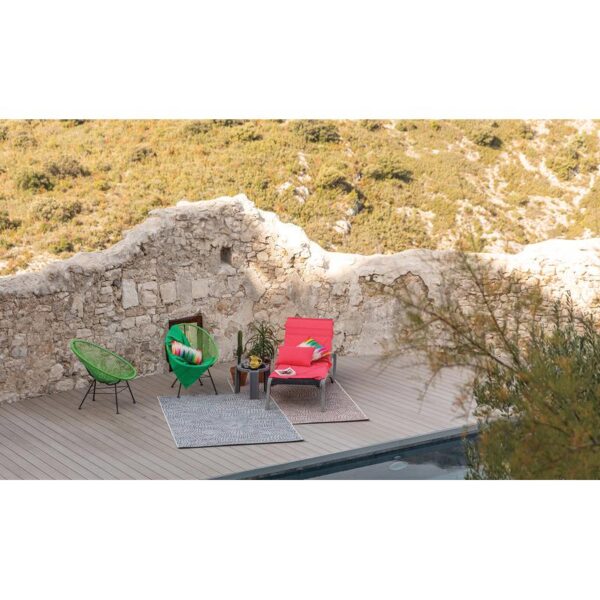 Deux chaises longues sur une terrasse à côté d'un mur.