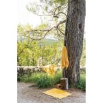 Une serviette jaune suspendue à une branche d’arbre.