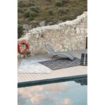 Une terrasse en bois avec une piscine et une chaise longue.