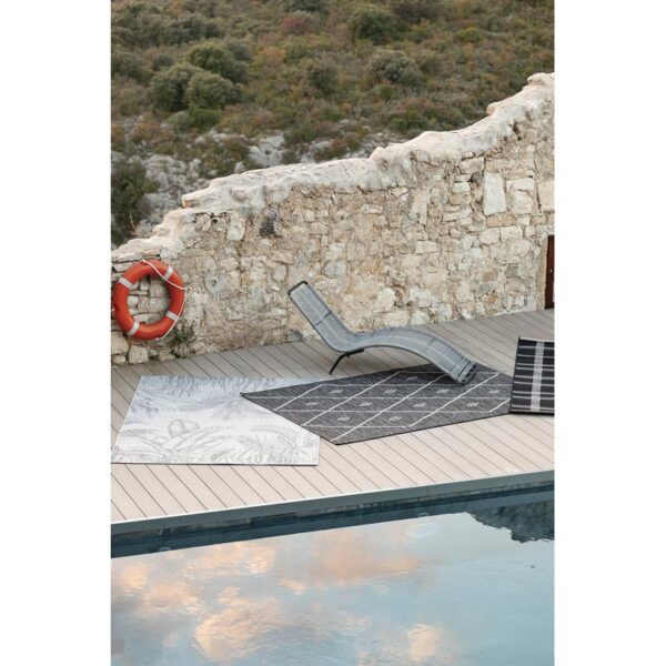 Une terrasse en bois avec une piscine et une chaise longue.