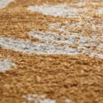 Une image en gros plan d’un tapis marron et blanc est présentée.