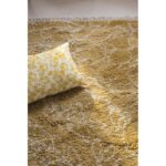 Un tapis jaune avec un oreiller dessus.