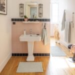 Une salle de bain avec des murs roses et un tapis rose.