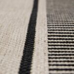 Gros plan d'un tapis à rayures noires et blanches, parfait pour ajouter une touche de sophistication à n'importe quelle pièce.