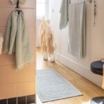 Une salle de bain avec des serviettes accrochées au mur.