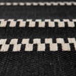 Un gros plan d'un tapis tissé noir et blanc.