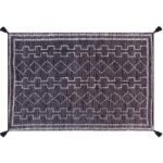 Un tapis noir et blanc avec des pompons.