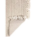 Plaid en tricot gris à franges pour décoration intérieure.