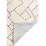 Tapis blanc et gris aux motifs géométriques.