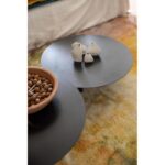 Une table basse noire avec un bol de noix.