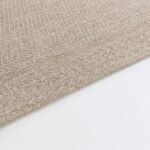 Tapis en textile beige à texture tissée.
