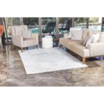 Salon moderne avec canapé et fauteuil élégants.