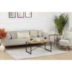 Salon moderne avec canapé, fauteuils et table basse.