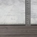 Mesure d'épaisseur d'un tapis gris.