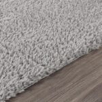 Tapis gris doux sur plancher en bois.
