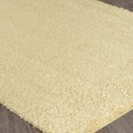 Tapis beige à poils longs sur sol en bois