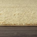 Tapis beige texturé sur plancher en bois