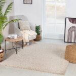 Salon moderne avec fauteuil, table et tapis beige.