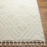 Tapis beige à motifs géométriques et franges.