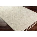 Tapis beige texturé avec franges sur plancher en bois