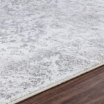 Tapis gris clair texturé sur sol en bois