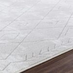 Tapis moderne gris clair géométrique sur parquet.